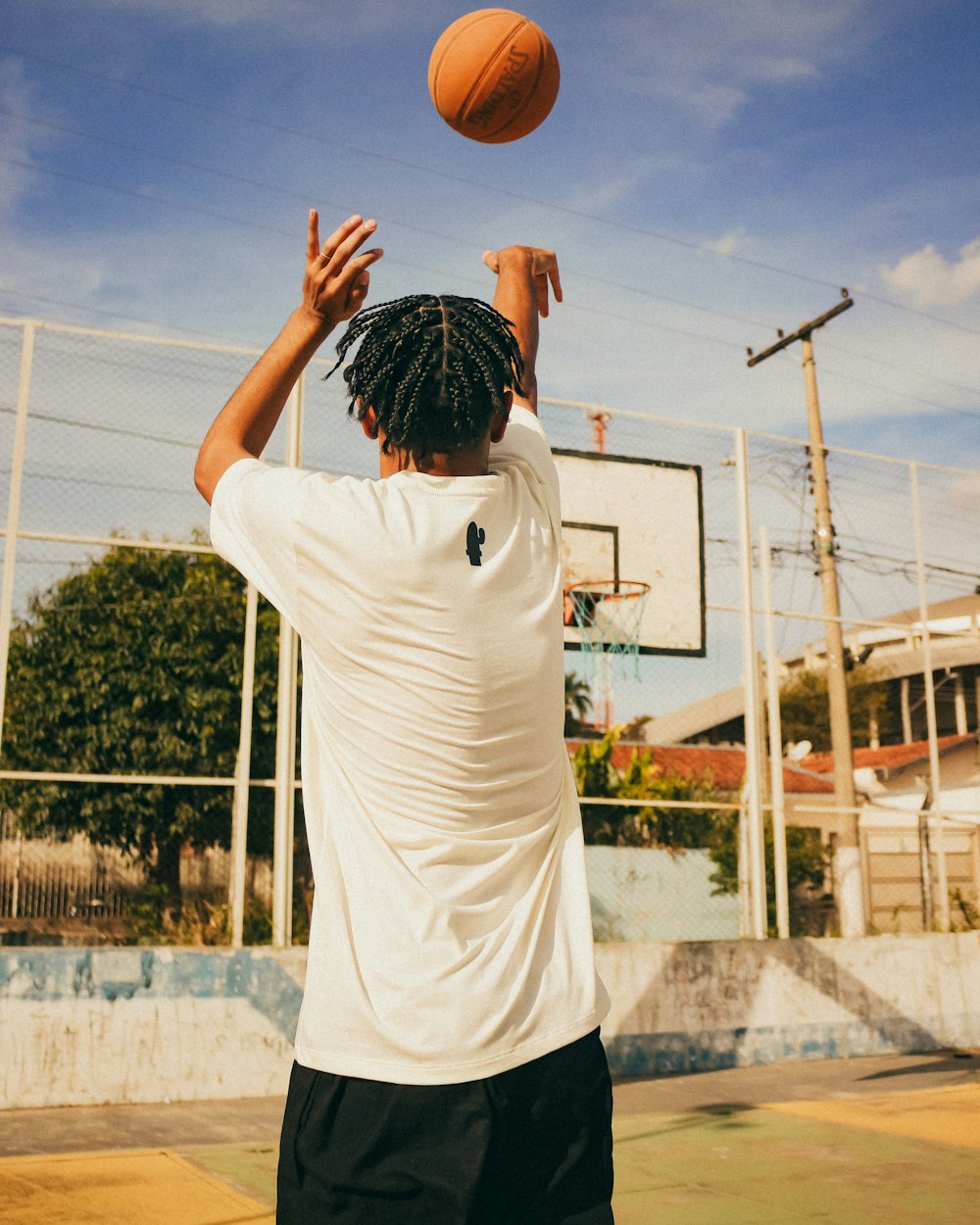 Joueur de basket au tir sur un terrain extérieur